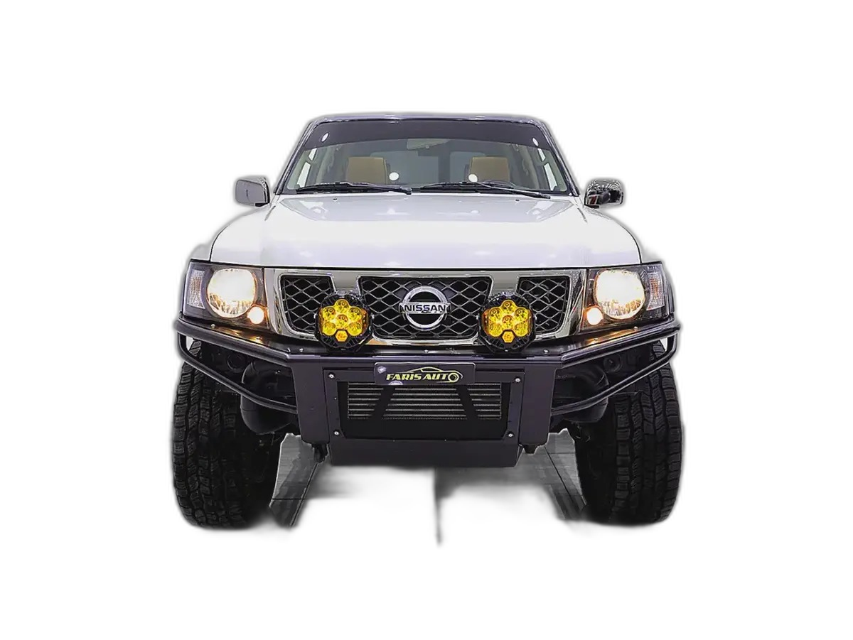 White Nissan Patrol sport build with steel front bumper, off-road driving lights and lifted suspension, front view