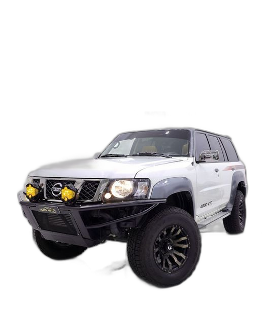 White Nissan Patrol sport build with off-road wheels and lifted suspension, side view